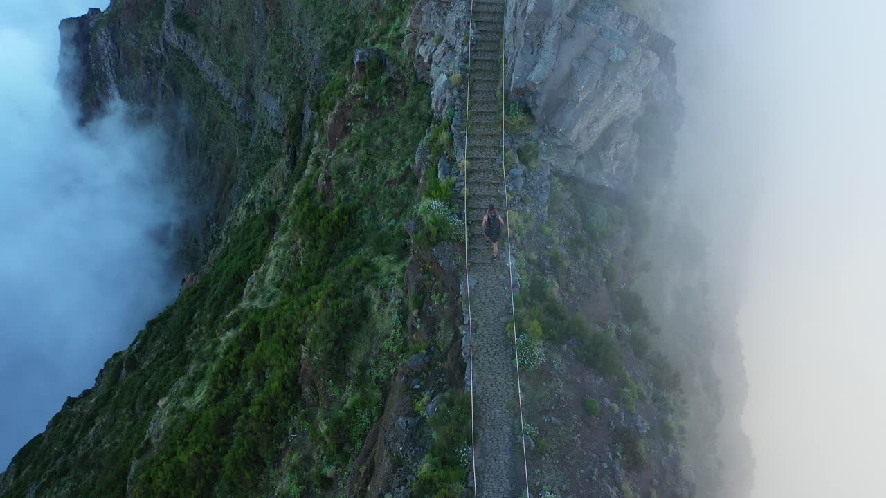 hombre joven y en forma está caminando solo por el sendero hasta la cima del pico do arieiro en madeira