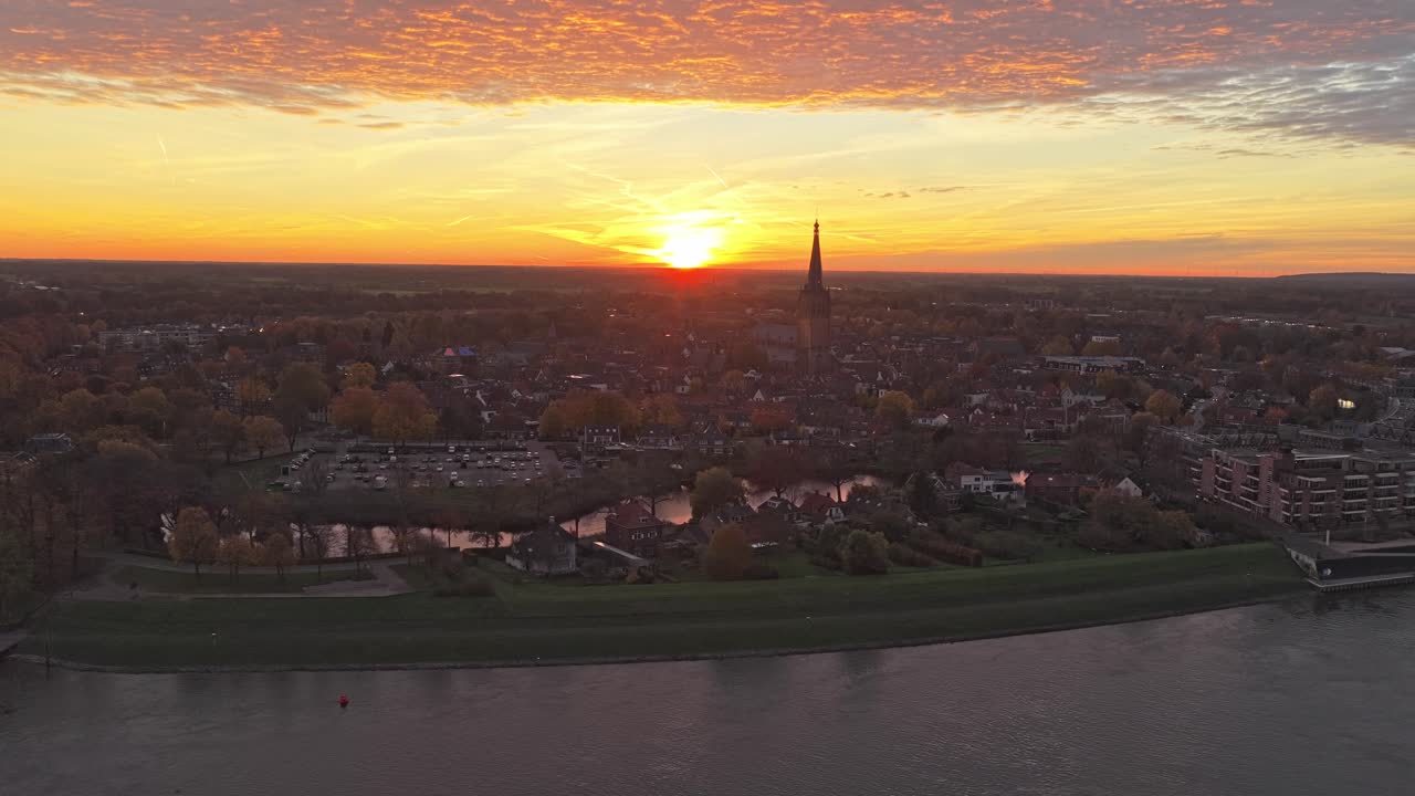 Droneperspektiv av Doesburg ved daggry, som avslører snødekte hus og glødende vinterhimmel