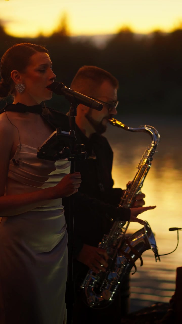 Elegante duo musicale che si esibisce con sassofono e voce al tramonto