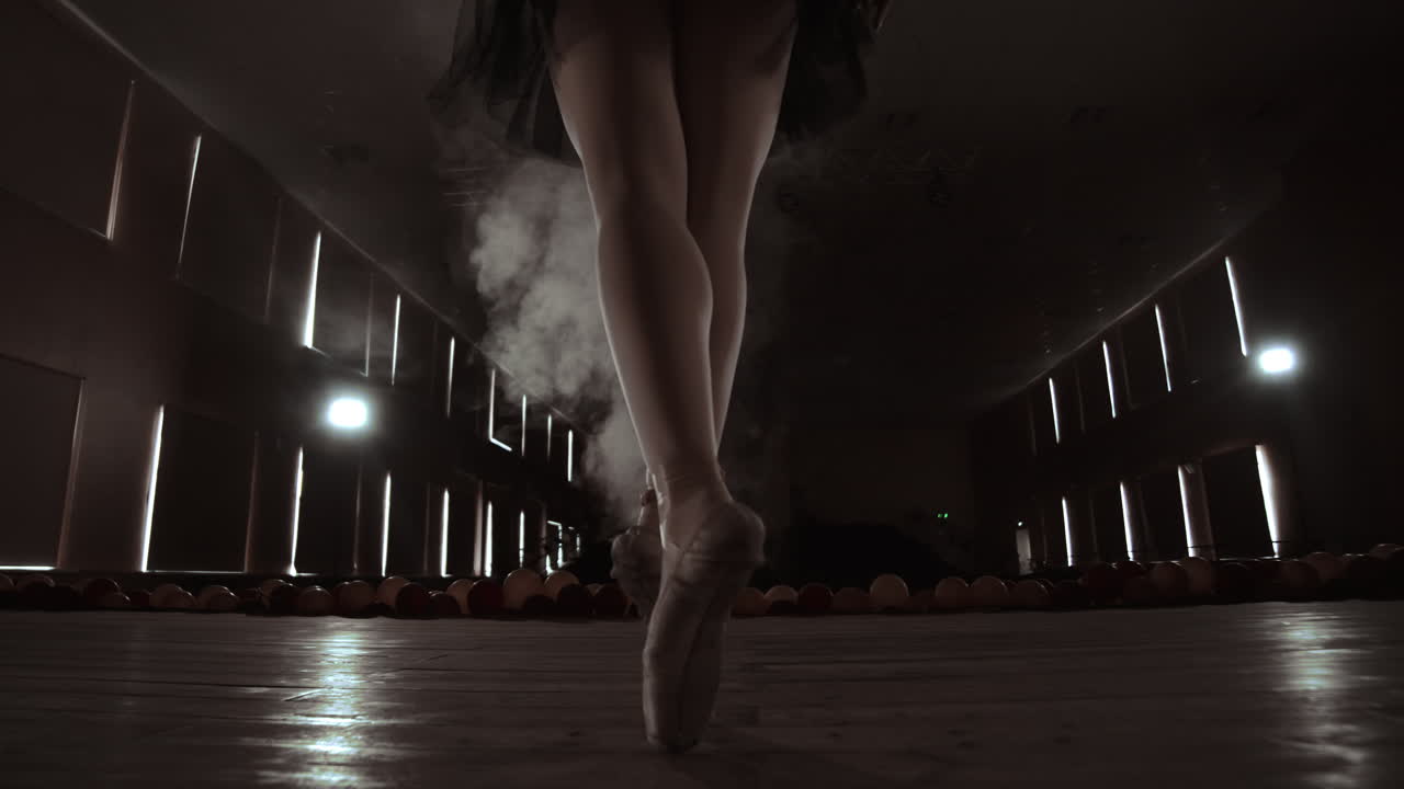 un primer plano de las piernas de la bailarina. ella baila con sus zapatillas de ballet. ella lleva un vestido de tutu negro. filmado en un estudio brillante y soleado. en cámara lenta.