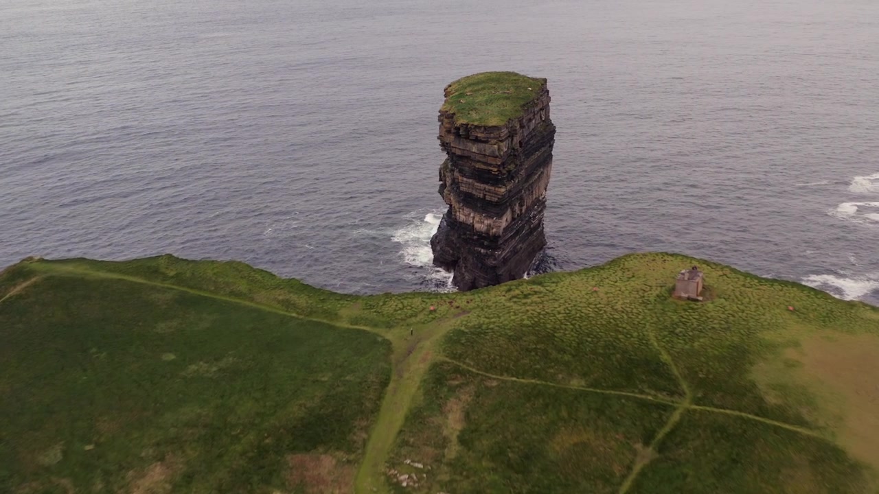 L'avvicinamento aereo scende verso le aspre scogliere e il faraglione Dun Briste a Downpatrick Head, Irlanda