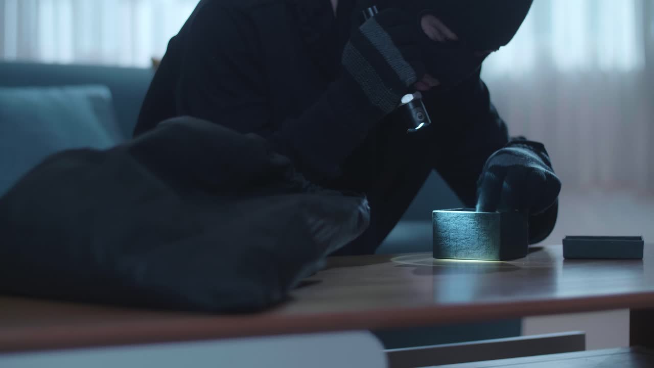 близкий взгляд на вора с фонариком, крадущего часы в чьем-то доме, прежде чем уйти.