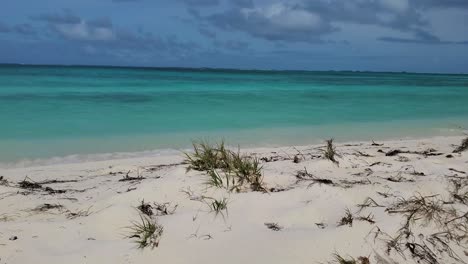 Tropical-lonely-idyllic-beach,-waves-breaking-on-shore,-white-sand-and-crystal-clear-sea-water