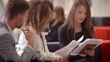 businesspeople meeting in busy lobby of modern office