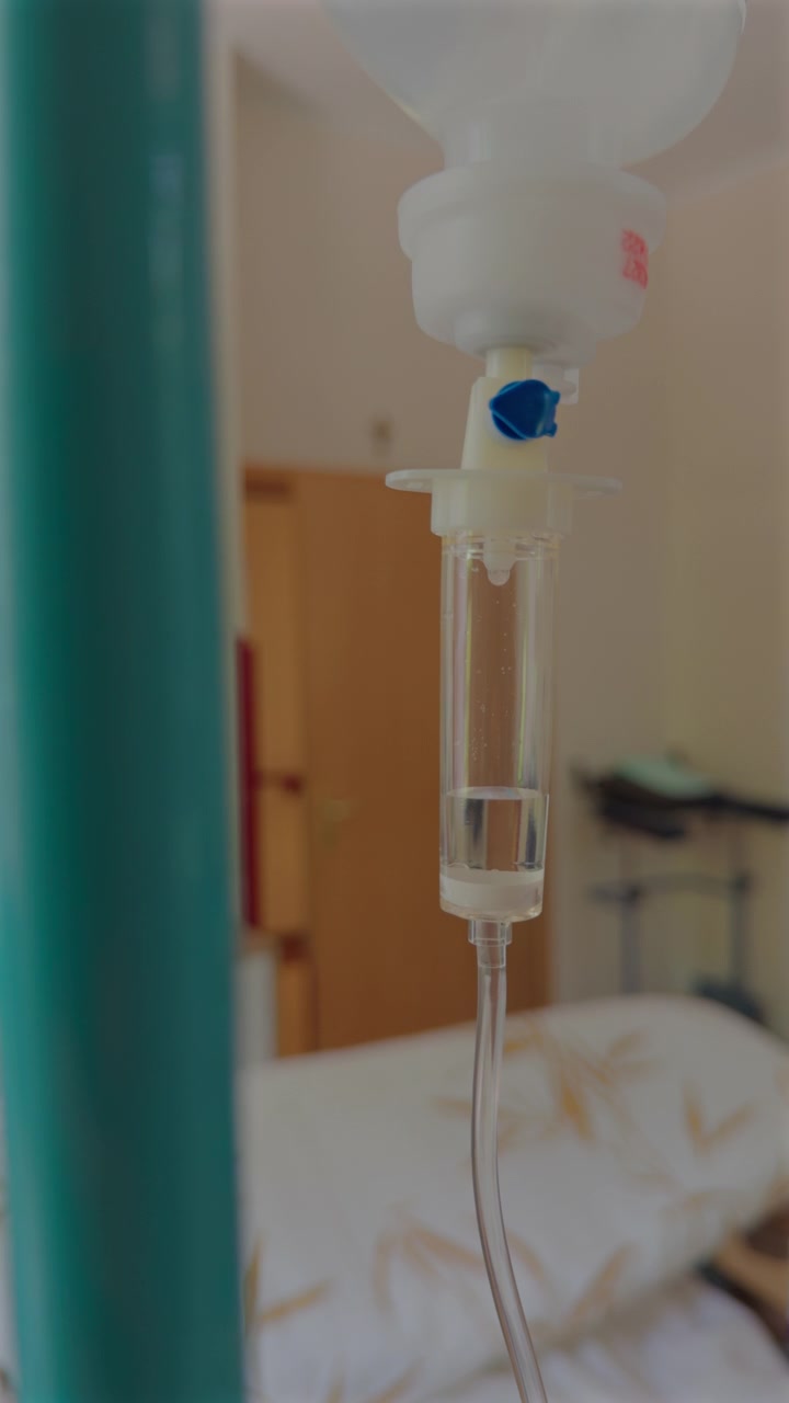 Flebo di soluzione fisiologica in una stanza d'ospedale, concetto medico di trattamento, emergenza, infusione di farmaci e chemioterapia. Terapia infusionale con flebo di vitamine in un contesto medico