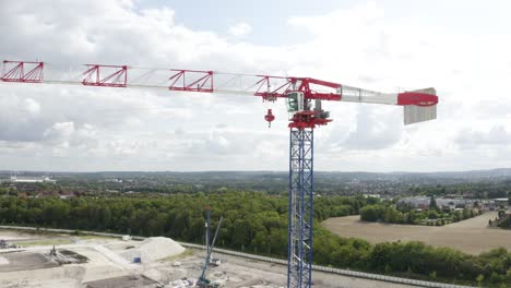 aerial drone tilt up shot of a large crane inside new constructions development site on a cloudy day