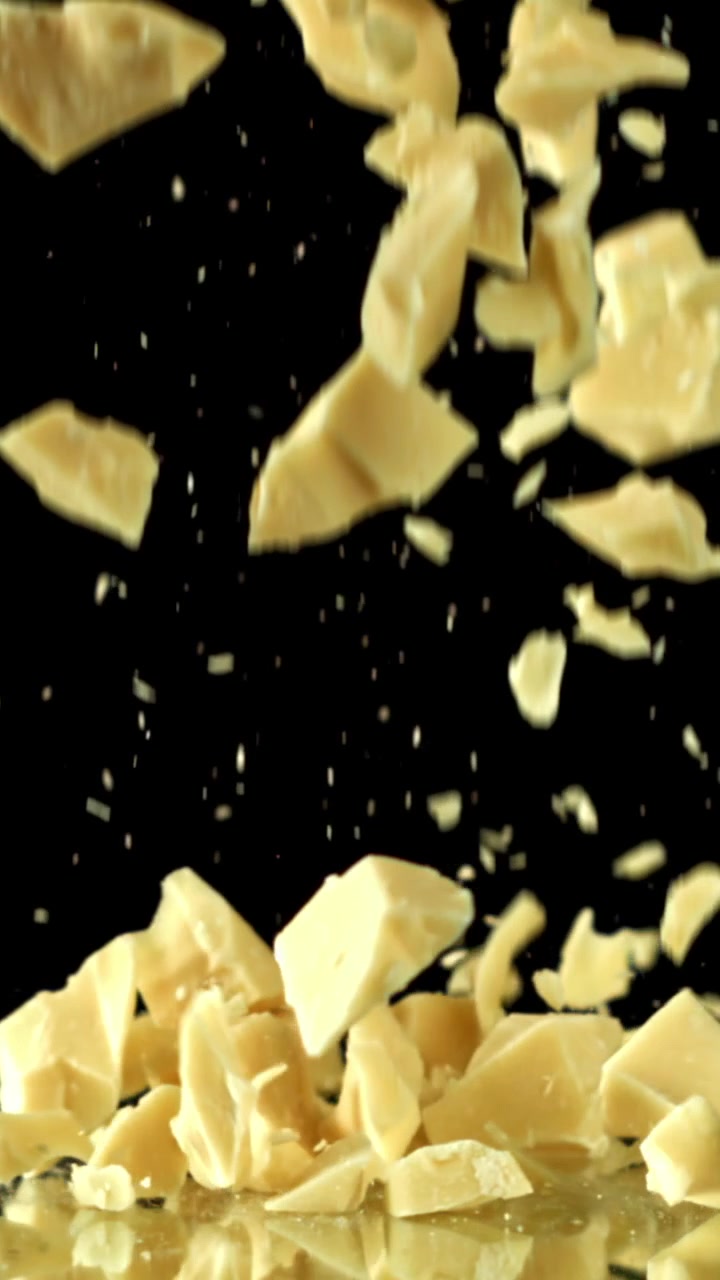 White Chocolate Pieces Falling in Slow Motion on a Reflective Surface