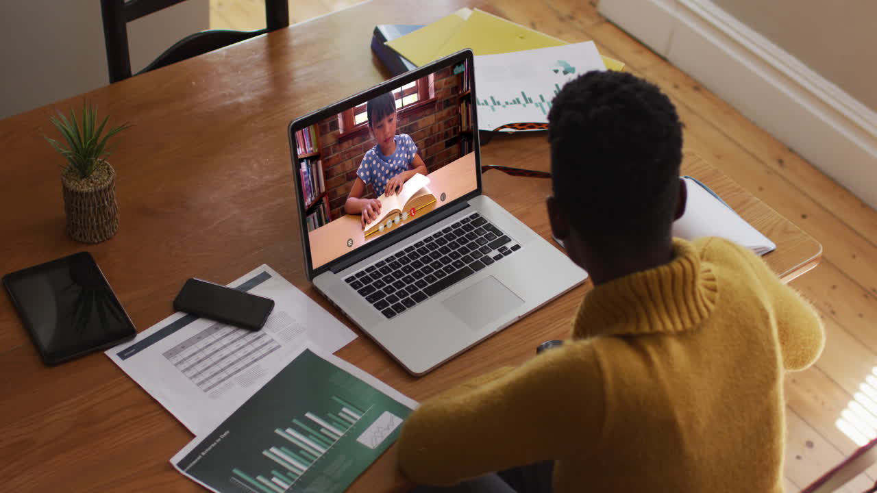 African american female teacher using laptop on video call with schoolgirl