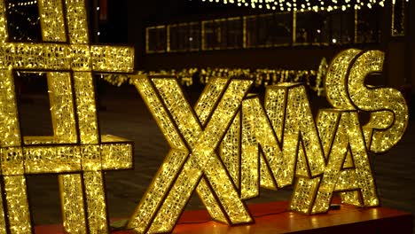 quick pan passing by a giant ornamental led christmas "xmas" letter sign at landsdowne park, in ottawa, canada