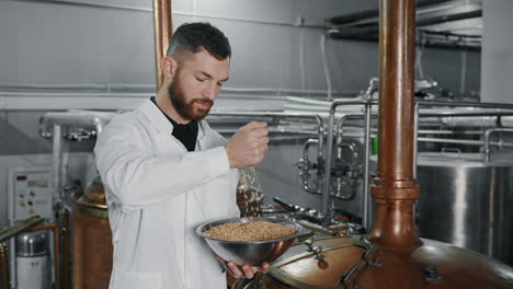 brewer adding barley to brewing tank