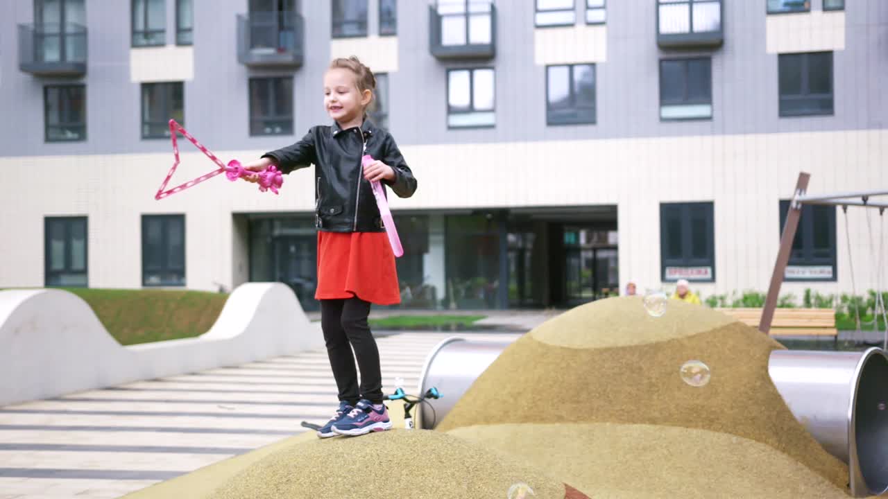 현대 도시 공원에서 거품으로 놀고 있는 소녀