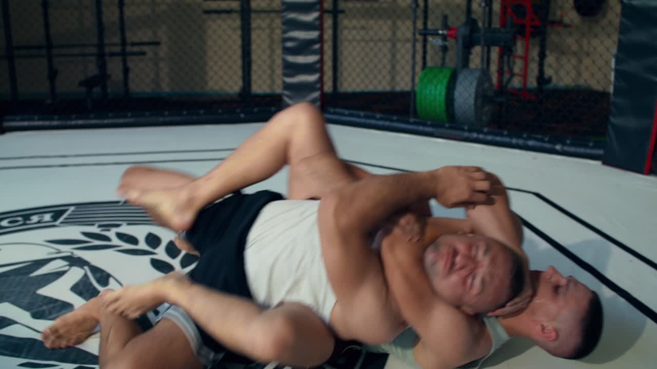 To mænd, der wrestler i et bur