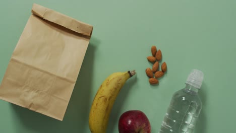 animation of paper lunch bag an fruits on blue background