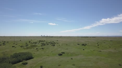 city skyline is revealed beyond a big hill