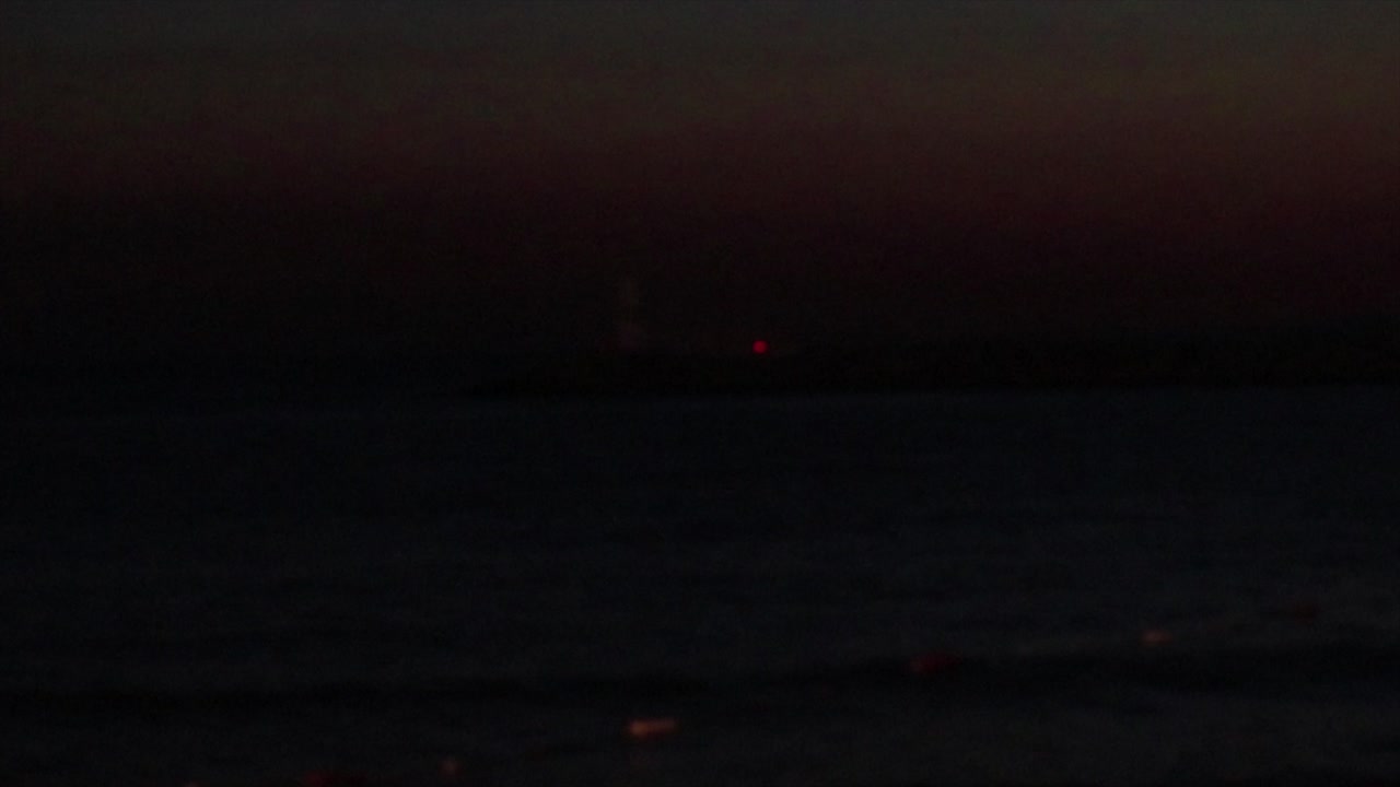 faro liberando luz roja en una oscuridad total