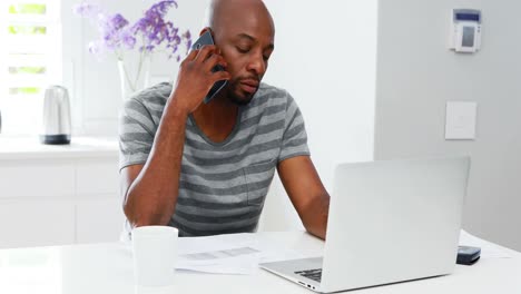 Hombre-Usando-Laptop-Mientras-Mujer-Hablando-Por-Teléfono-Móvil-4k