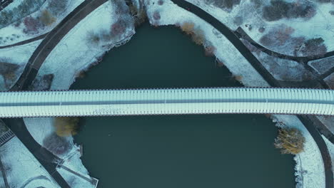 top down aerial view of hurka luziny metro bridge above lake in winter season, prague, czech republic