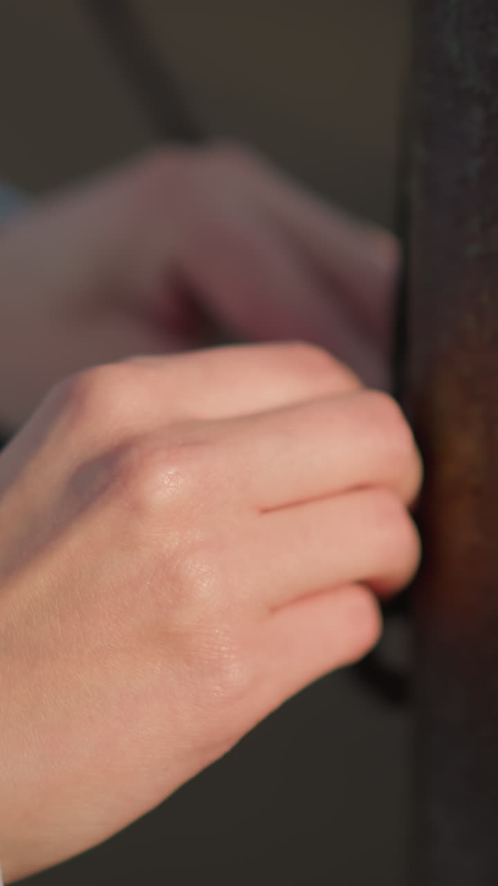 야외 스포츠 환경에서 배구 망을 가지고 서서 대화하는 사람을 보여주는 흐릿한 배경으로 배구 을 가지고 놀고 있는 손의 클로즈업