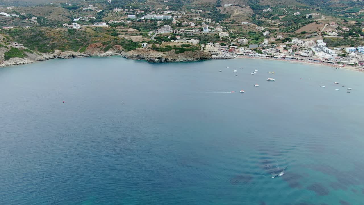 Aerial view of a beautiful coastal town surrounded by transparent water in the island of Crete