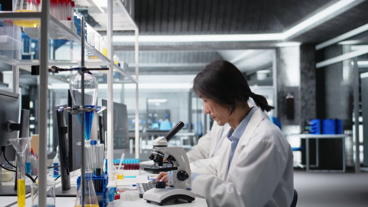 Vertical video Senior microbiologist in lab using scientific microscope to detect disease