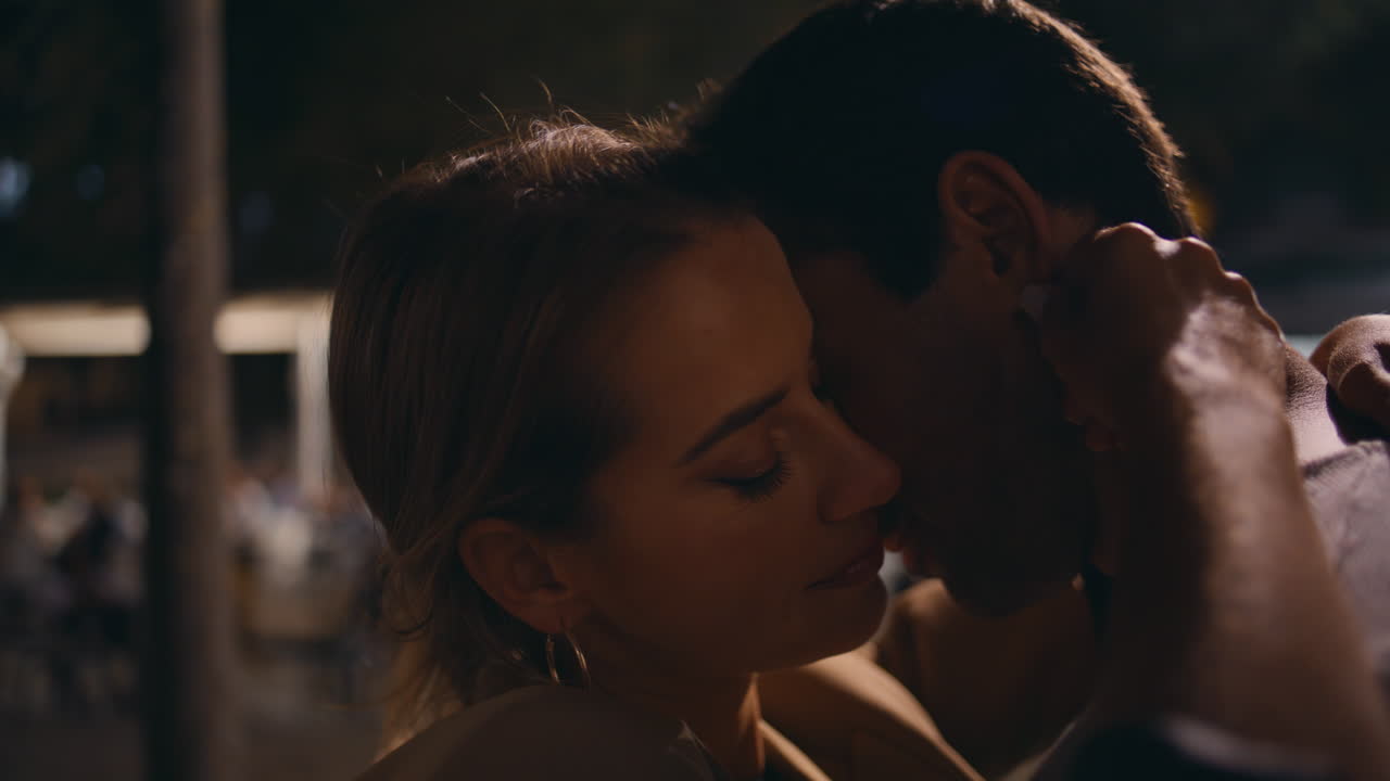Zärtliche Liebende schauen sich in die Augen und berühren sich im Gesicht (Nahaufnahme). Sanftes Paar bei einem Abend-Date.