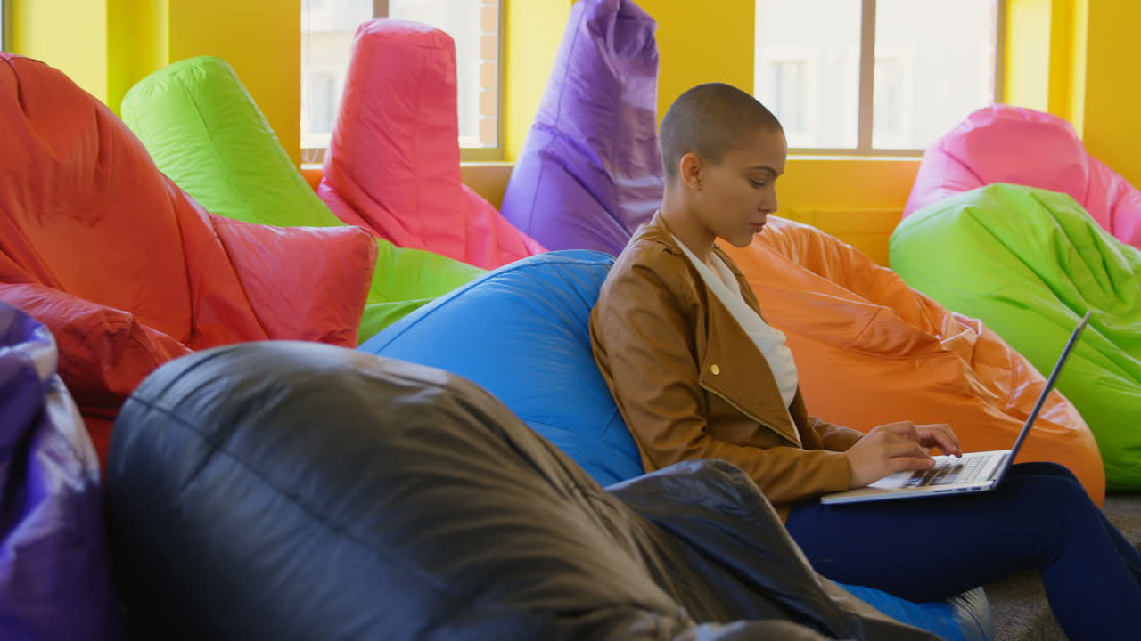 vista lateral de una joven ejecutiva caucásica usando una computadora portátil en la oficina 4k