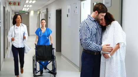 Man-embracing-pregnant-woman-in-corridor