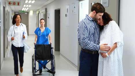 man embracing pregnant woman in corridor