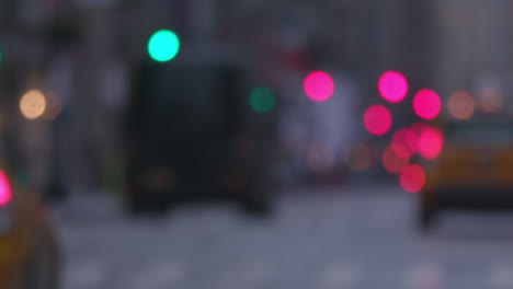 blurred slow-mo of a wet new york manhattan main street with traffic, yellow taxi, out of focus lights