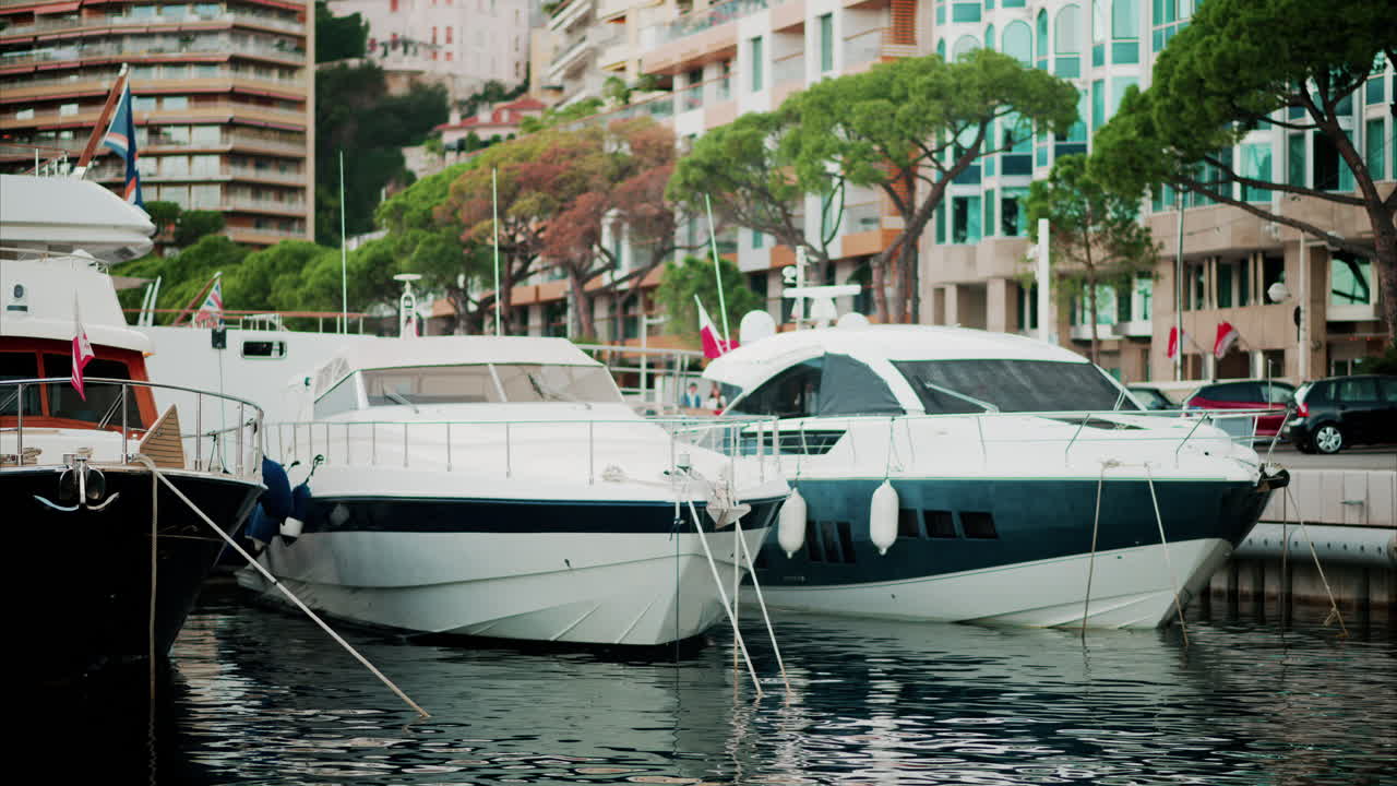 View of boats docked in the Monaco Marina with the skyline of the city on the background