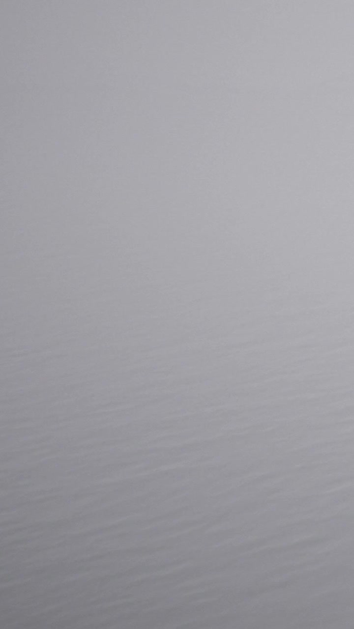 Superficie d'acqua calma che riflette il cielo nuvoloso in un luogo tranquillo di giorno
