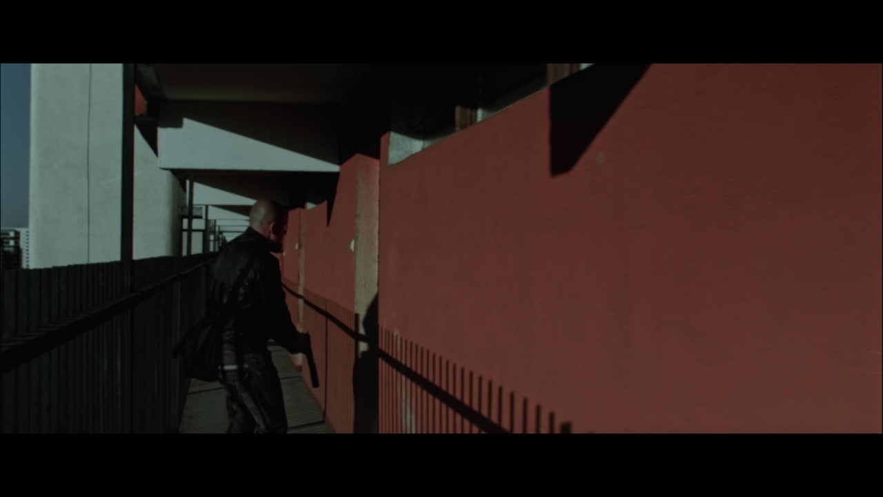 A bald dangerous looking man enters apartment building flat