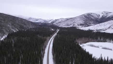 Wide-Aerial-View-of-Chena-Hotsprings-Road-during-Alaska-Wintertime,-Frozen-Pond,-and-Lush-Green-Spruce