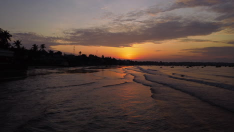 antena cinematográfica sobrevuelo tranquilo océano playa orilla al atardecer