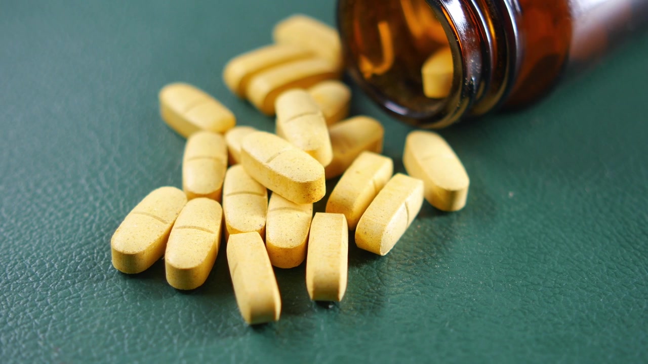 Yellow Pills Spilled from a Brown Glass Bottle