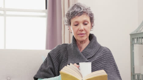 Concentrated-woman-reading-a-book-while-drinking-coffee