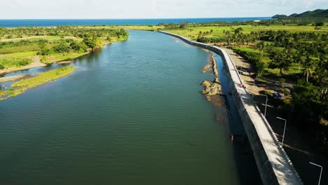 panoramic view of a tropical river along newly built boulevard walkway during sunset at pajo river, catanduanes, philippines - aerial flyover