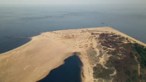 aerial top down of sandy beach ans coastline in gdansk and calm baltic sea in backdrop