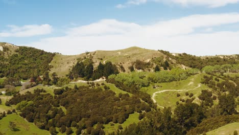 Hills-and-forest-drone-footage-with-roads-going-up-hill