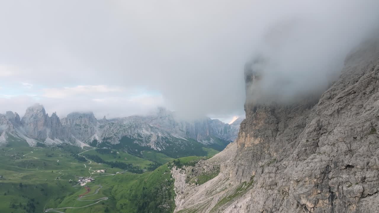 imágenes aéreas cinematográficas, la ciudad de corvara emerge contra el escarpado telón de fondo de los dolomitas en paso gardena