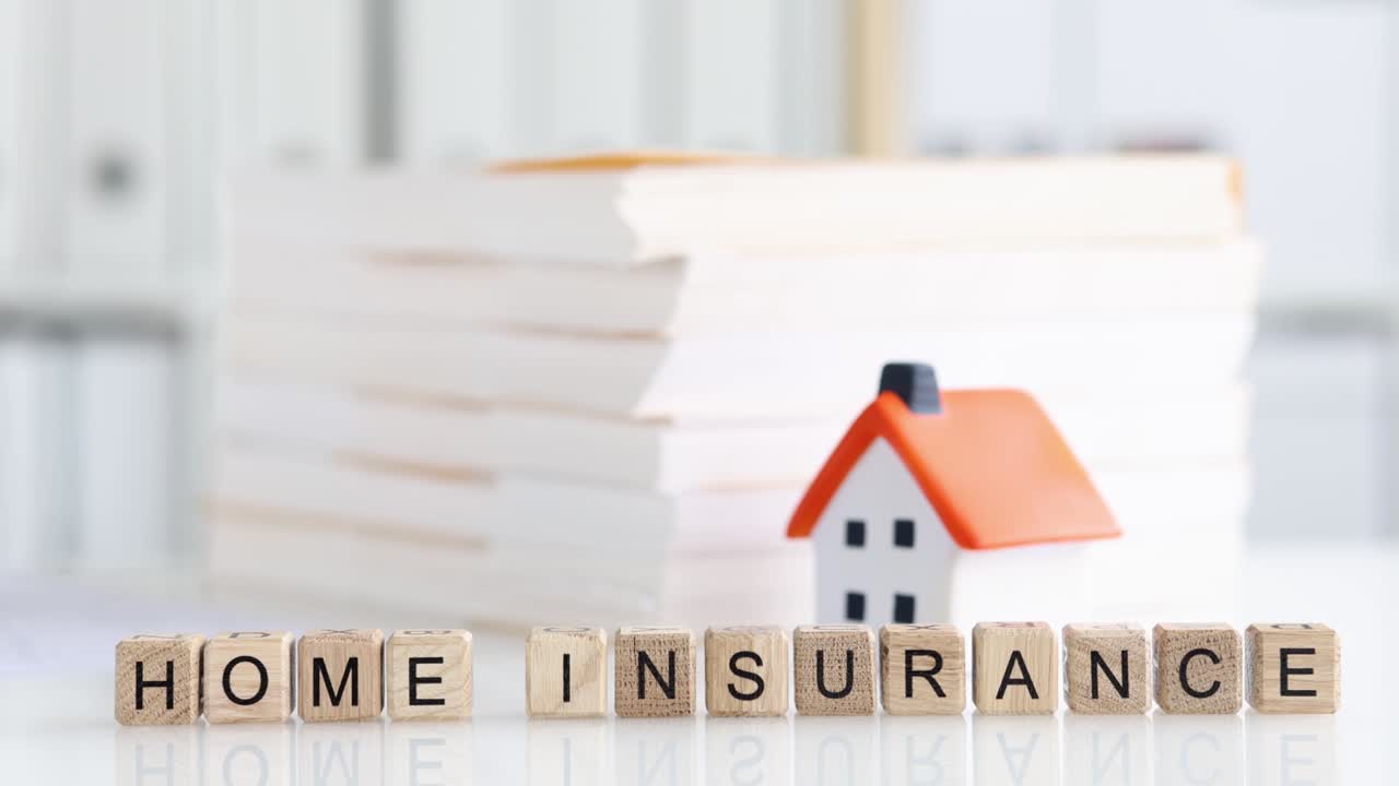 Home insurance documents lying near toy house 4k movie slow motion