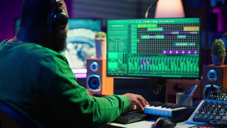 Audio-engineer-working-in-home-studio-with-digital-software-on-pc