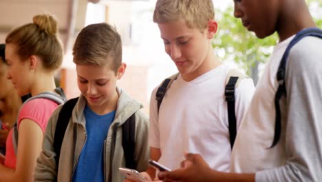 grupo de amigos de la escuela usando teléfono móvil 4k