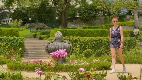 Joven-Turista-Pelirroja-Con-Gafas-De-Sol,-Paseando-Por-Los-Jardines-Del-Palacio-De-Cristal-En-Oporto-Durante-Sus-Vacaciones