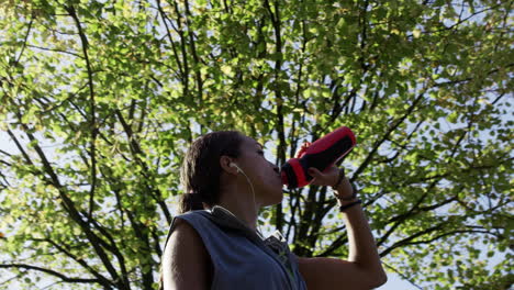 runner woman drinking water bottle sun flare solar energy