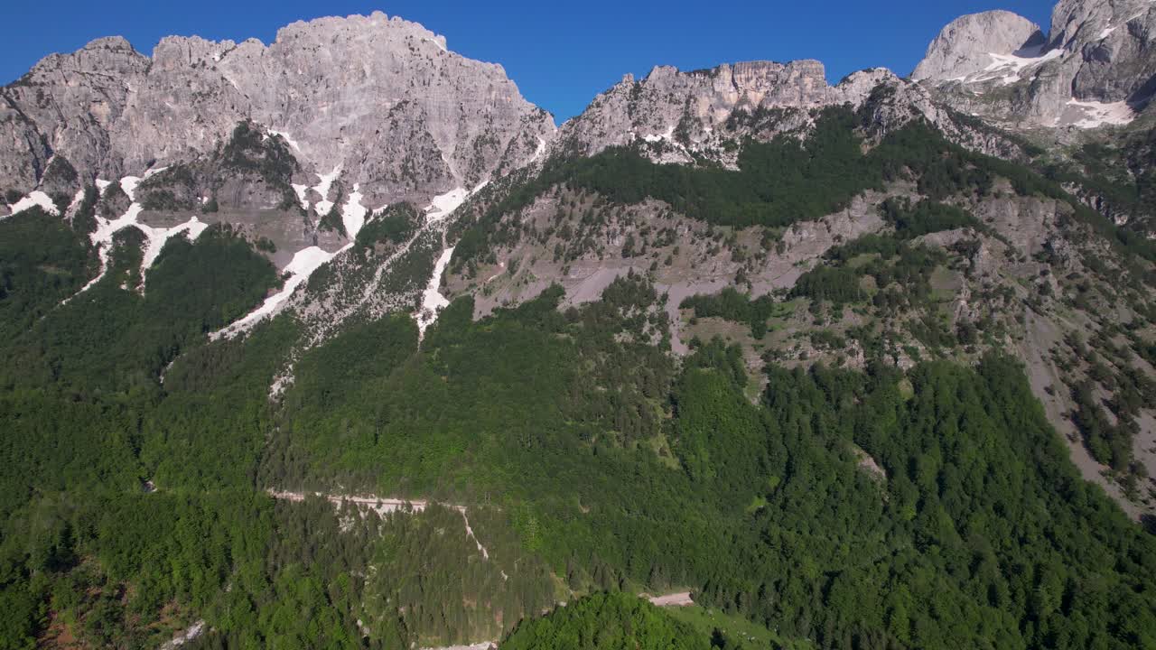 cordillera épica, nieve blanca glaciar en las laderas de los alpes rocosos y verdes bosques salvajes en albania