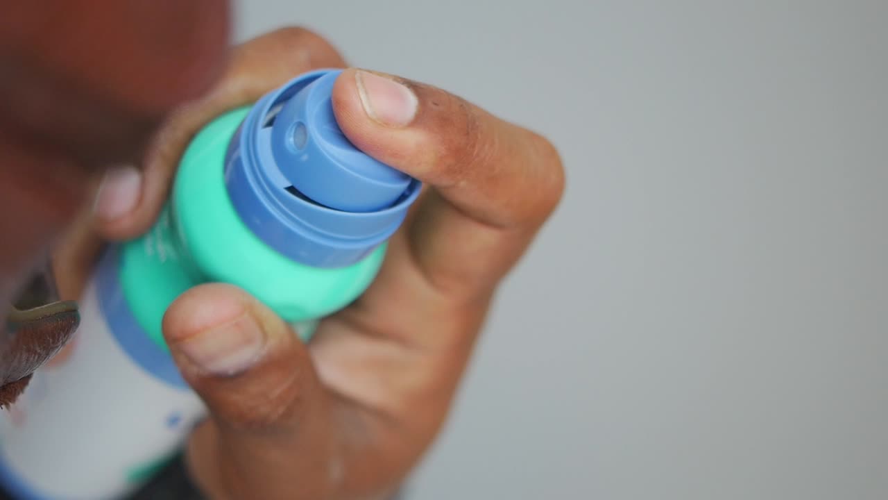 Close-up of a hand spraying an aerosol can