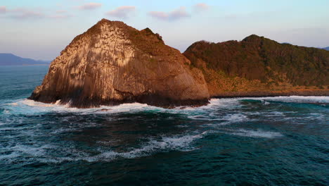 Tiro-De-Dron-Giratorio-De-La-Puesta-De-Sol-En-Una-Gran-Roca-En-El-Océano-En-Kyushu-Japón