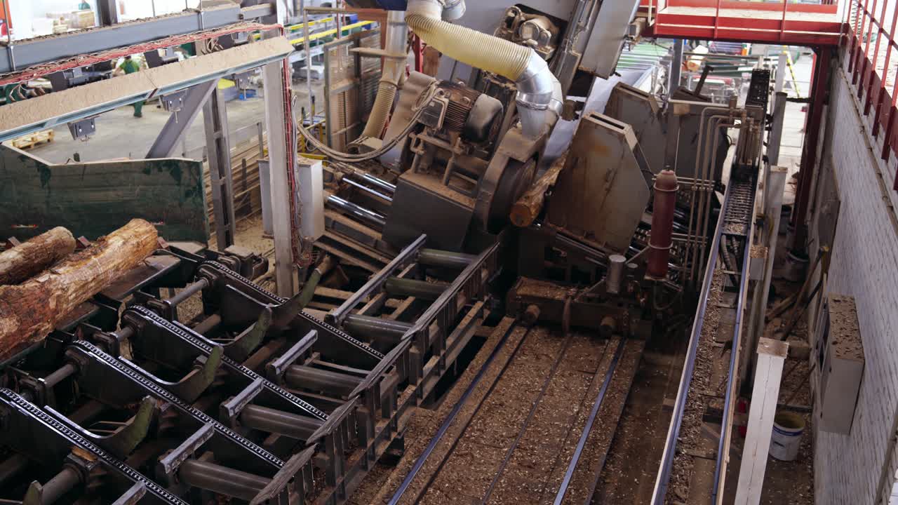 Forest product industries. Sawmill. Process of machining logs in a machine, Heavy industry equipment. Closeup. view from the top. Wood industry facilities.