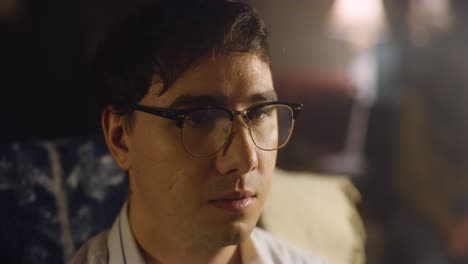 man sweats awkwardly on couch at party.